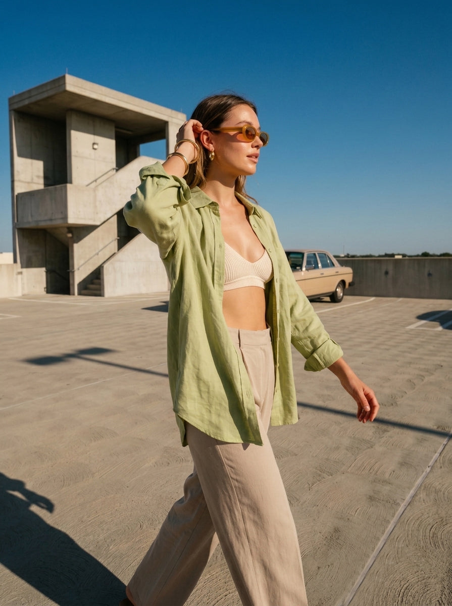 Women walking on a roof while wearing a green open shirt and beige linen pants as part of qunzy studio campaign