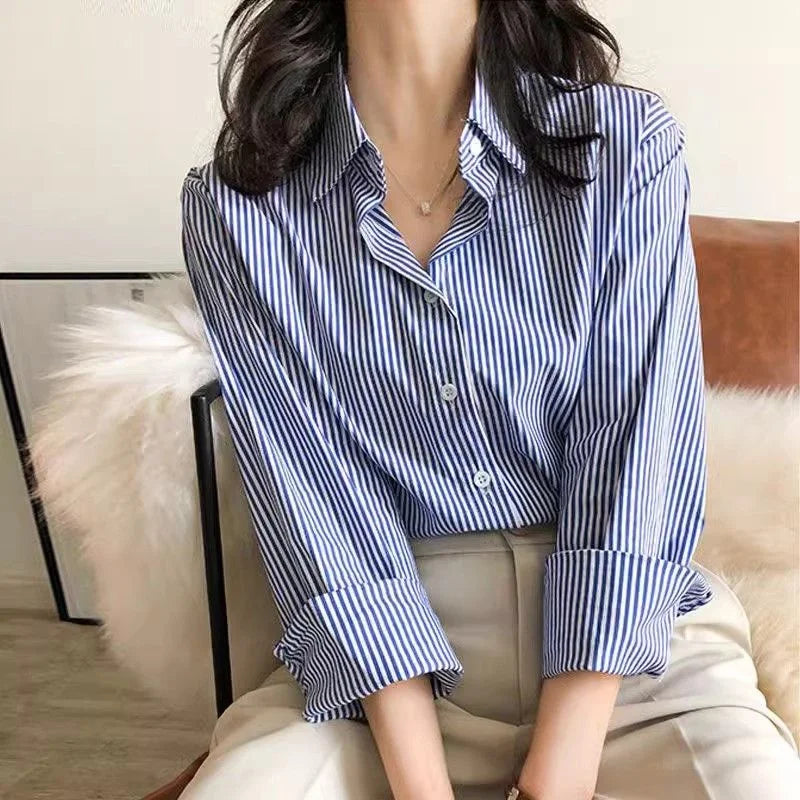 Person wearing a blue and white striped shirt sitting on a couch.