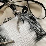 Bolso de mano con patrón de cocodrilo y forma de serpiente