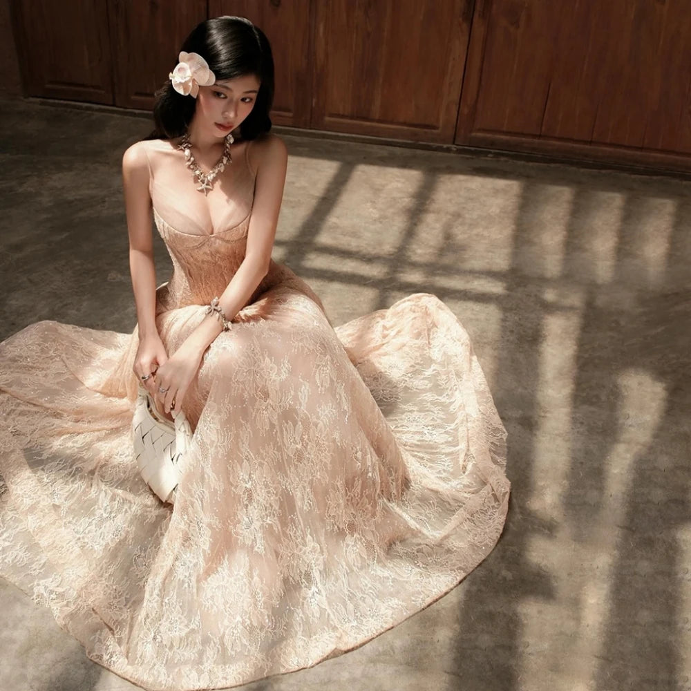 Woman in a flowing dress sitting on the floor with wooden panels in the background