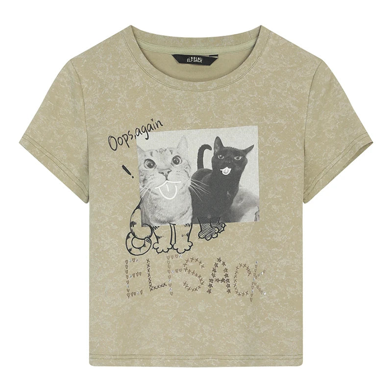 A short-sleeve t-shirt in a light beige/khaki color with a distressed texture. The front features a graphic print of a gray tabby cat and a black cat with the text 'Dogs again' and 'ELPSACK' below.