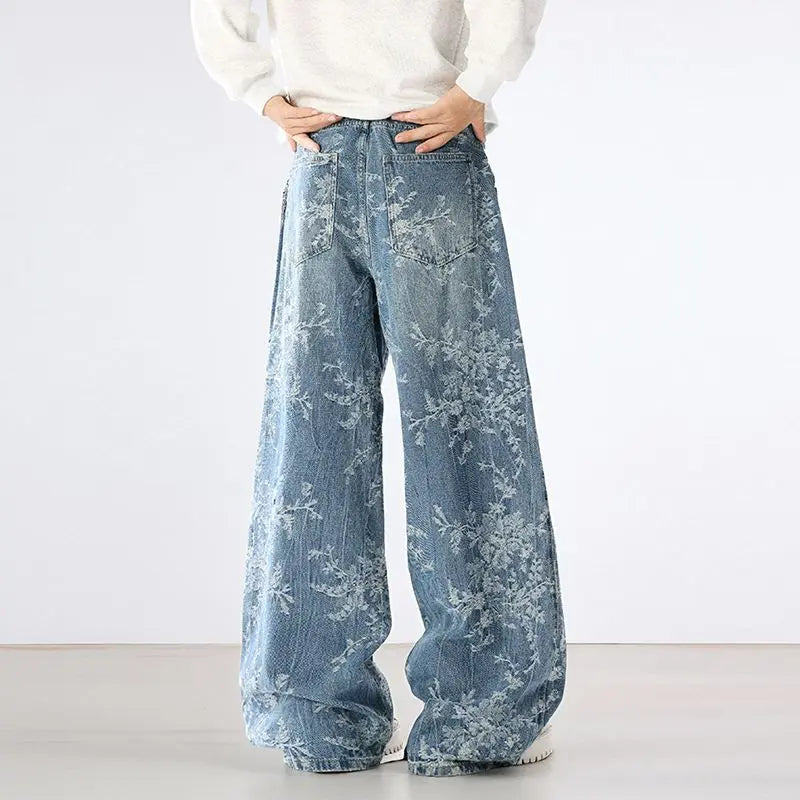 Person wearing light blue floral-patterned wide-leg jeans on a white background