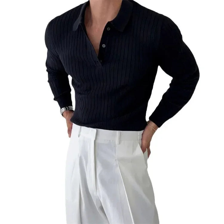 Person wearing a dark ribbed sweater and white pants on a light background