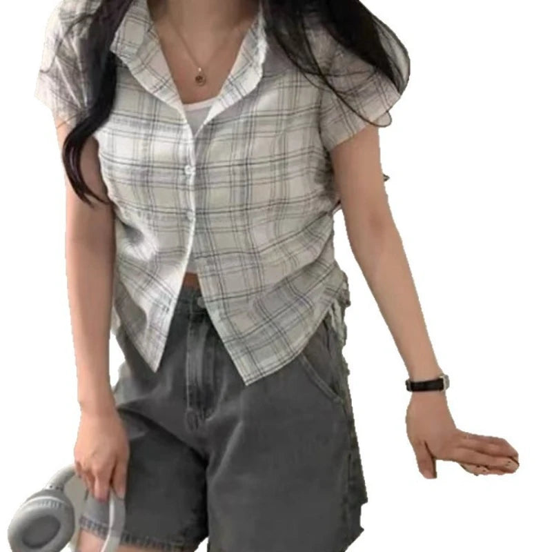 Person wearing a plaid shirt and gray pants on a white background