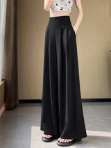 Person wearing black wide-leg pants in a minimal indoor setting