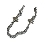 Silver bracelet with star-shaped ends on a reflective surface