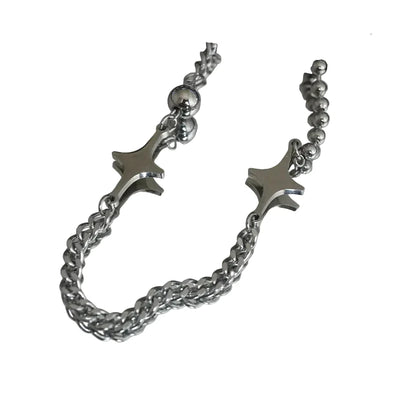 Silver bracelet with star-shaped ends on a reflective surface