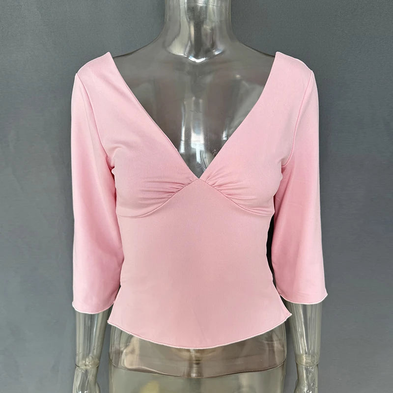 Pink long-sleeve top on a mannequin against a gray background