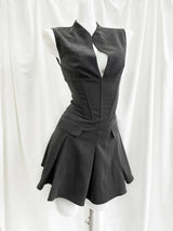 Black sleeveless dress on a mannequin against a white curtain background