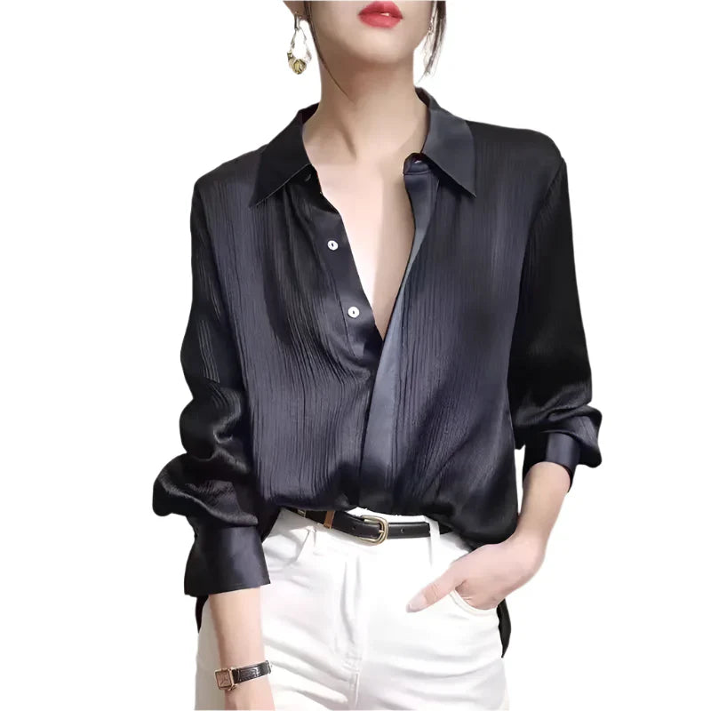 Person wearing a black satin shirt with white pants on a plain background