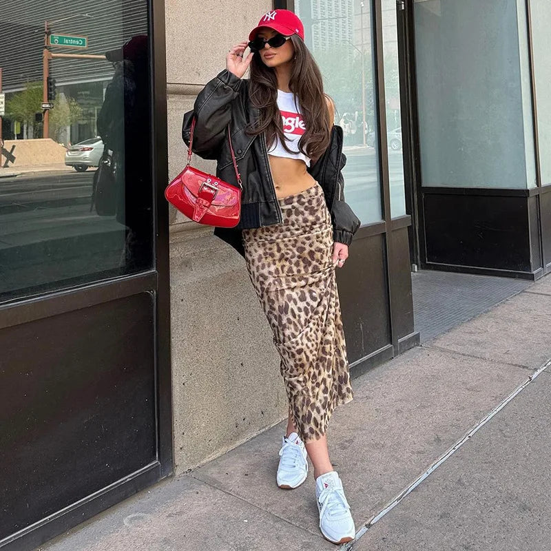 Woman in leopard print skirt and red cap standing on a sidewalk
