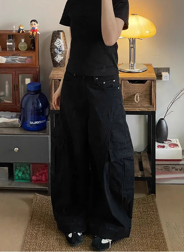 Person wearing a black outfit in a room with wooden furniture and decor items.