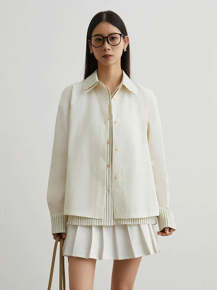 Woman wearing a cream-colored jacket and skirt on a plain background