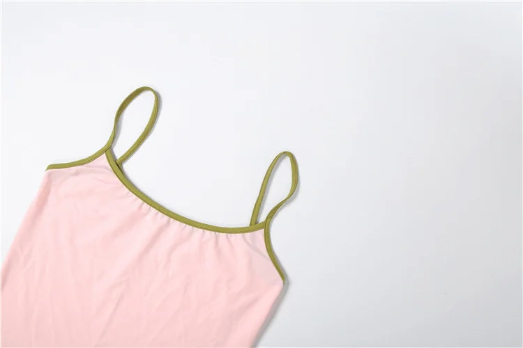 Pink dress with green straps on a light gray background