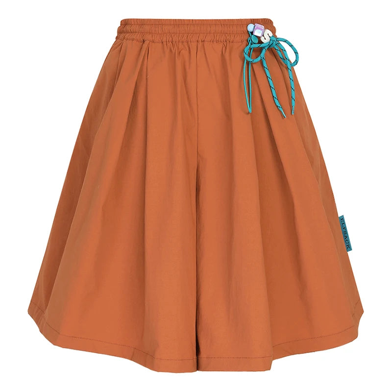 An orange pleated shorts with an elastic waistband and a turquoise drawstring tied in a bow, shown against a plain white background.