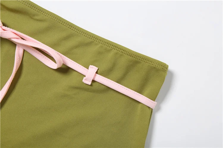Green swimsuit with pink straps on a white background
