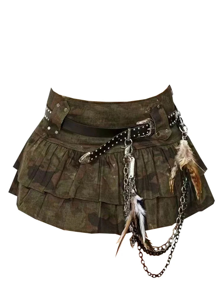 A stoked, punk-style mini skirt in olive green camouflage fabric, featuring pleated layers, a black studded belt, silver chain accents, and feathers, shown against a plain white background.