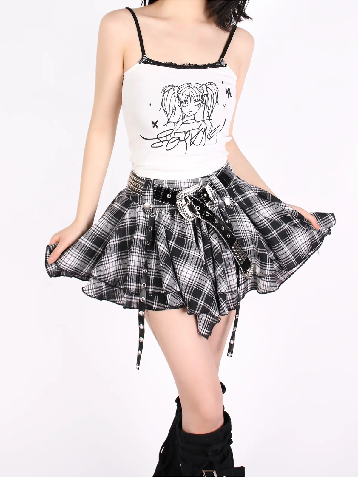 Person wearing a white tank top with black text and graphics, plaid skirt, and black high-heeled boots on a white background