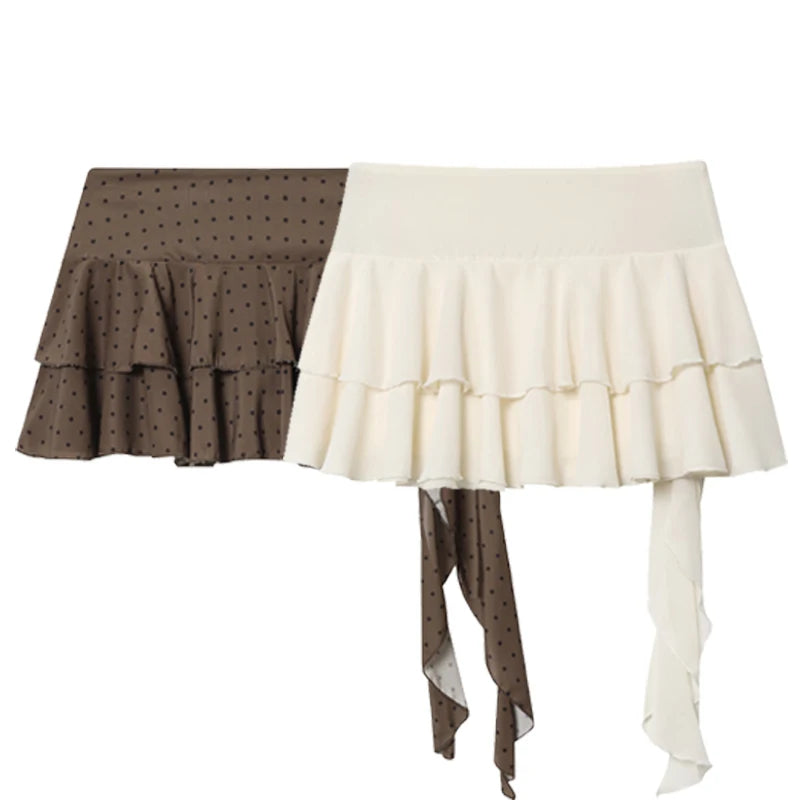 Two ruffled mini skirts shown side by side on a plain white background. The left skirt is brown with a small black polka dot pattern and layered ruffles, with a matching tie detail hanging down.