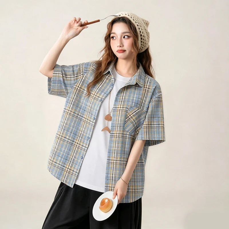 Woman wearing a plaid shirt over a white top, holding a plate with an egg and a straw hat on a plain background