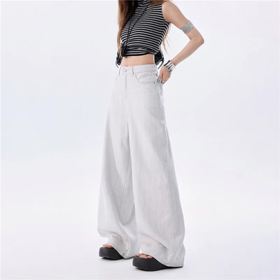 A model wearing high-waisted, wide-leg white pants paired with a black and white striped crop top and black platform sandals, shown from the waist down on a white studio background.