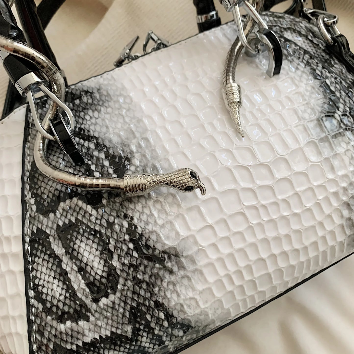 Bolso de mano con patrón de cocodrilo y forma de serpiente