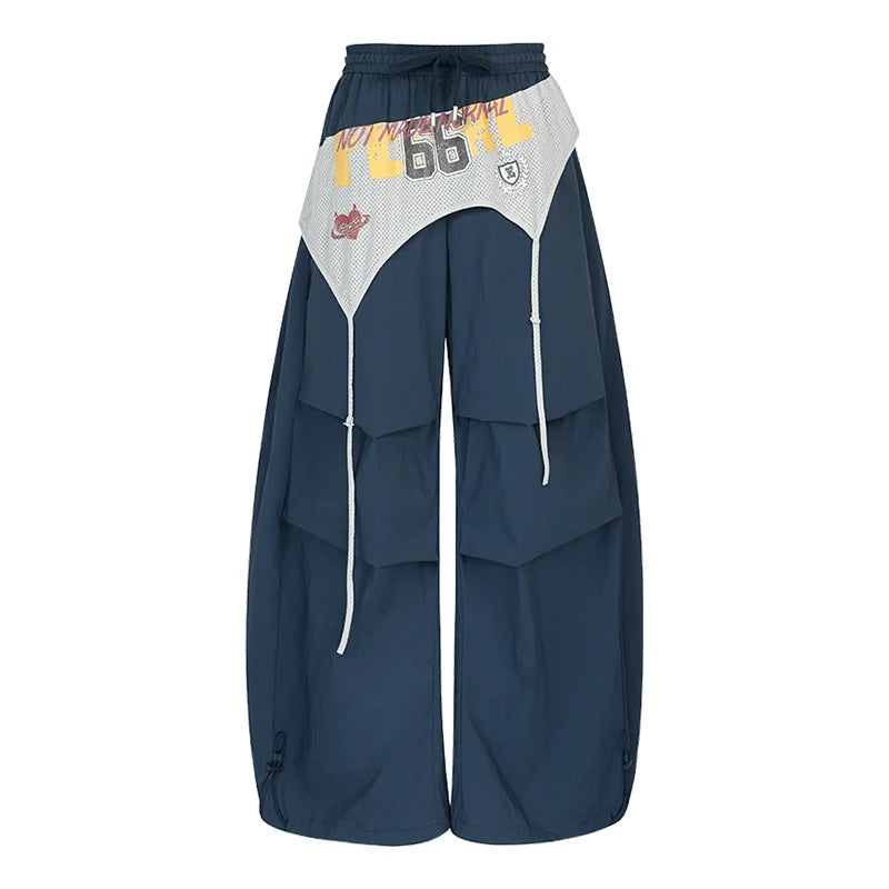 A pair of wide-leg cargo pants in navy blue with a contrasting light gray and yellow waist panel featuring the number '66' and graphic details, shown against a plain white background.