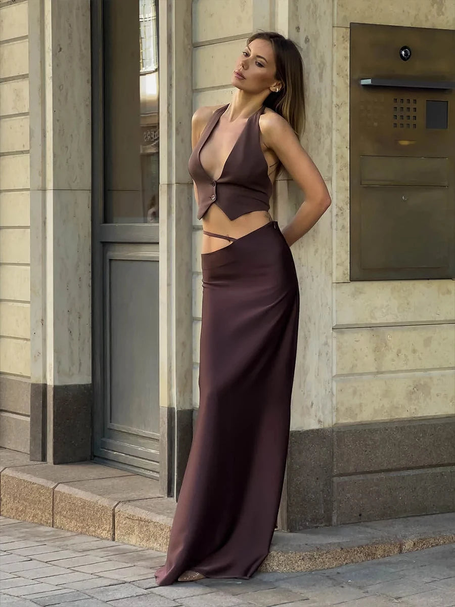 Woman wearing a brown dress against a white wall