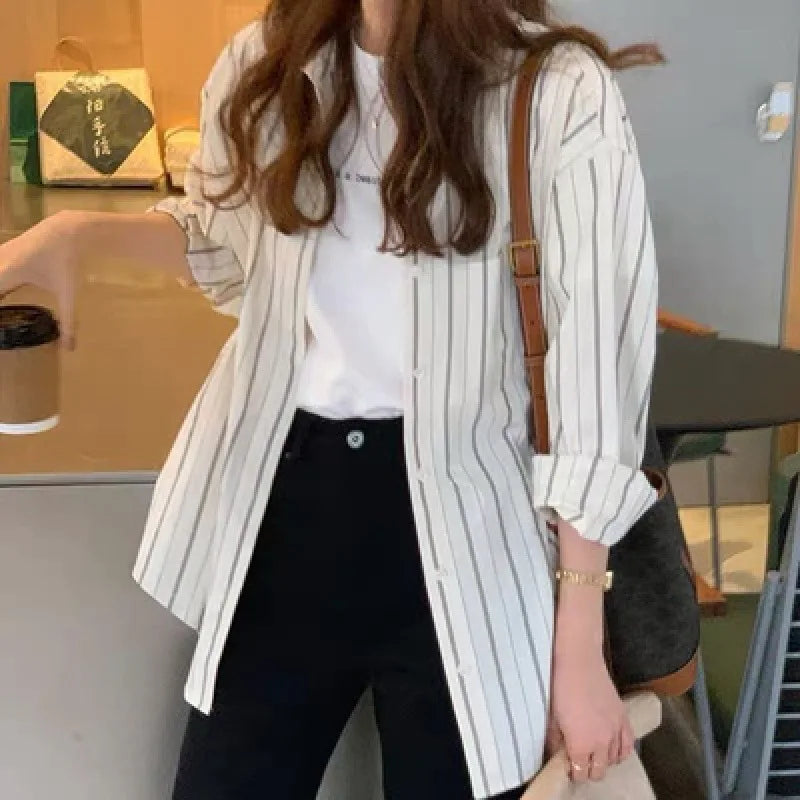 Person wearing a striped shirt and black pants in an indoor setting